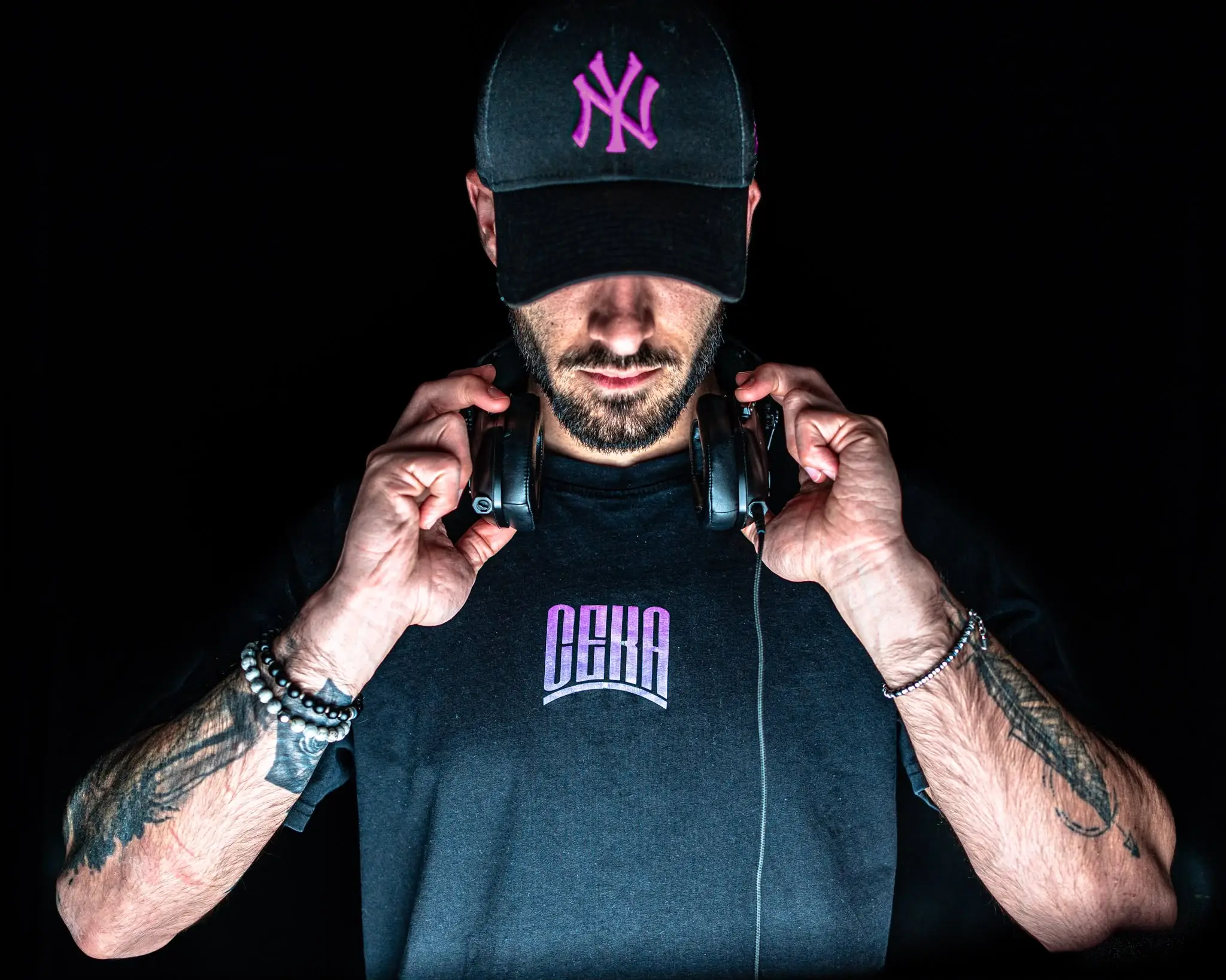 CEKA con il cappellino e le mani sulle cuffie
